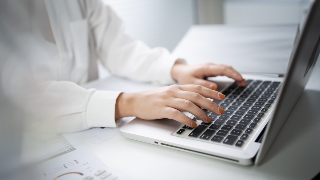 Woman working by using a laptop computer Hands typing on keyboa